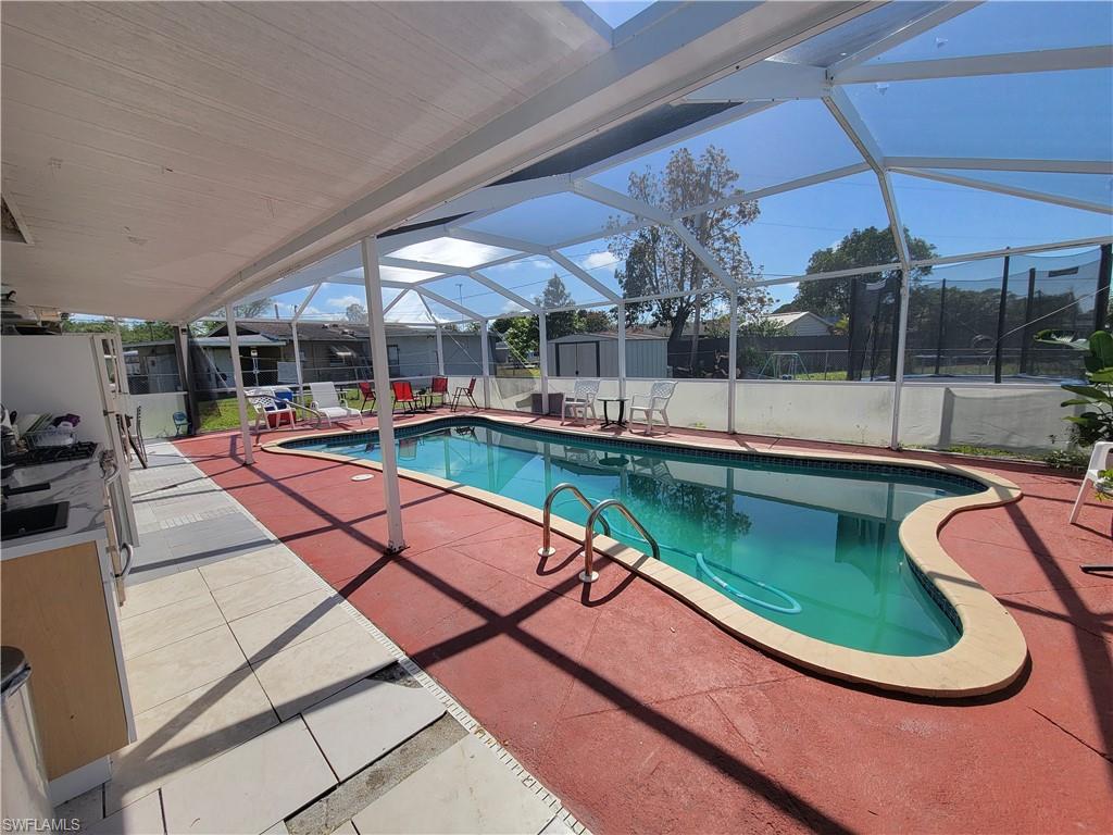 10 East Jersey Road Lehigh Acres, FL 33936 - Photo 23 of 32 View of swimming pool featuring a shed, a patio area, a fenced backyard, an outbuilding, and a fenced in pool