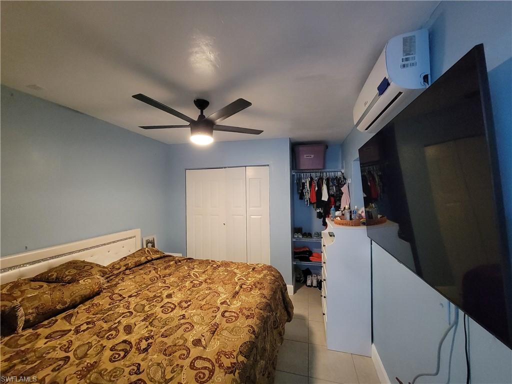 10 East Jersey Road Lehigh Acres, FL 33936 - Photo 32 of 32 Bedroom featuring a wall mounted AC, light tile patterned floors, a closet, and ceiling fan