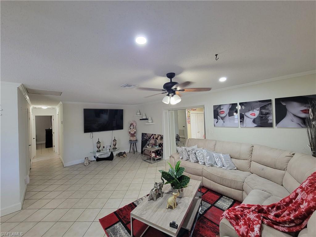 10 East Jersey Road Lehigh Acres, FL 33936 - Photo 7 of 32 Living room with recessed lighting, light tile patterned floors, crown molding, visible vents, and ceiling fan