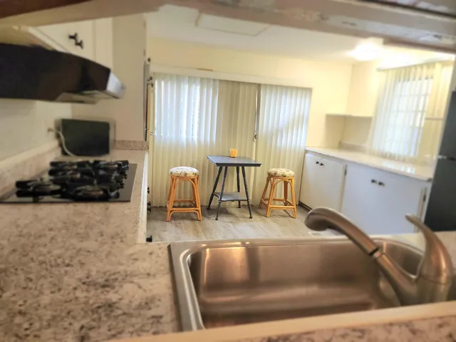a living room with furniture a flat screen tv and kitchen view