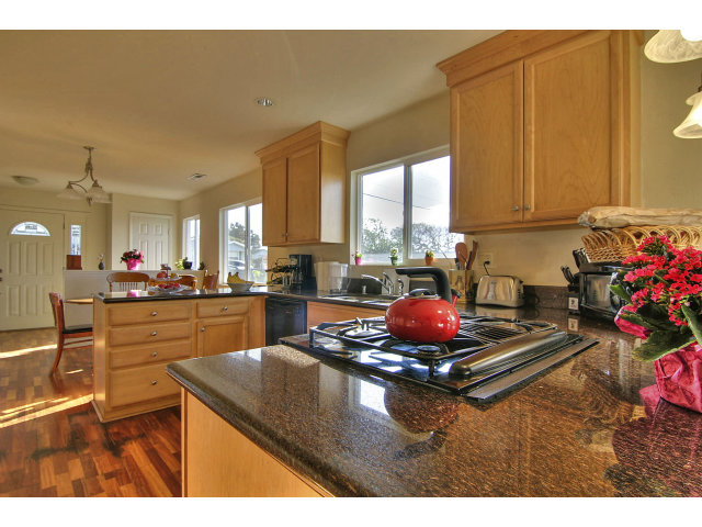 1289 Trinity Avenue Seaside, CA 93955 - Photo 4 of 13 a kitchen with kitchen island granite countertop a stove window and cabinets