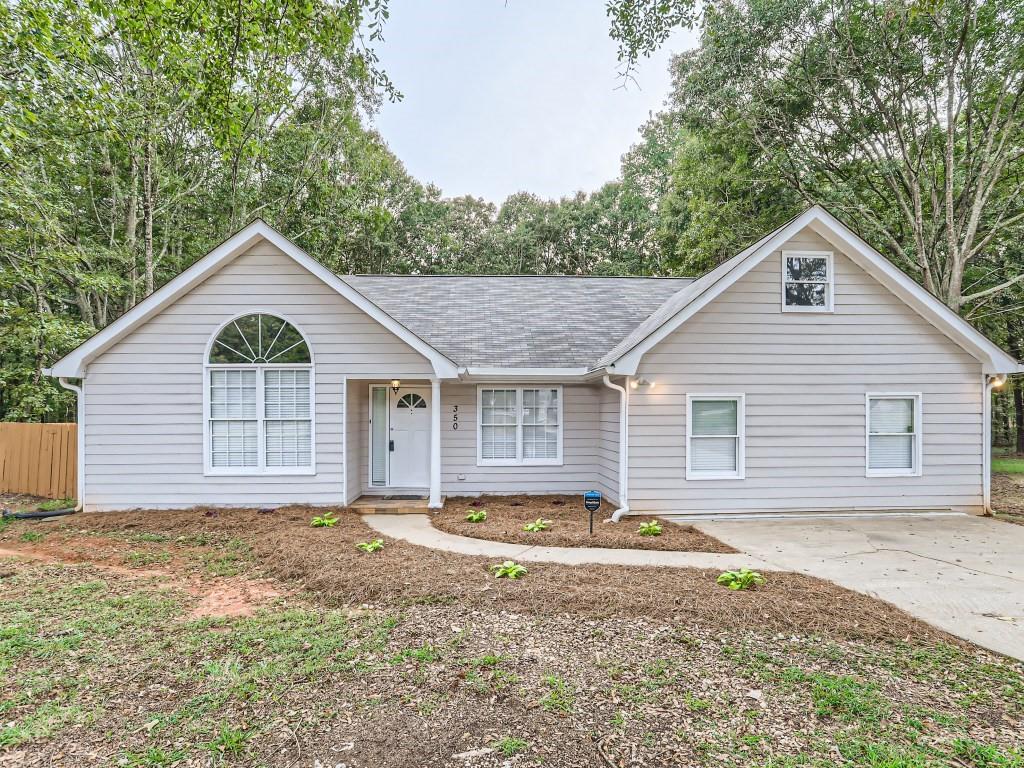350 Cowan Road Covington, GA 30016 - Photo 1 of 1 a front view of house with yard and trees in the background