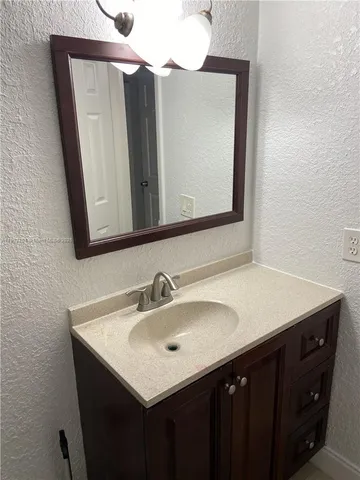 a bathroom with a sink vanity and a mirror