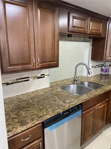a kitchen with granite countertop stainless steel appliances and sink