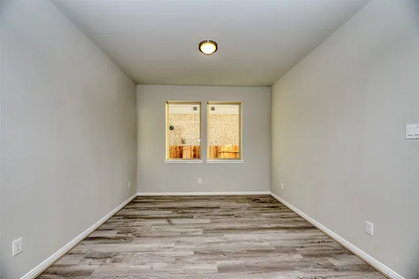 an empty room with a window and a fan