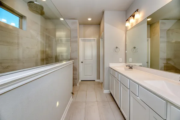 a en suite bathroom with a double vanity sink and a large mirror