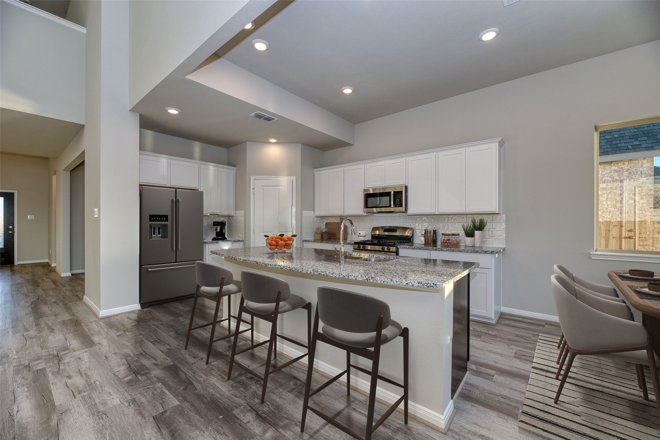 21122 Sunlight Grv Drive Rosharon, TX 77583 - Photo 3 of 45 a kitchen with stainless steel appliances a dining table chairs refrigerator and microwave