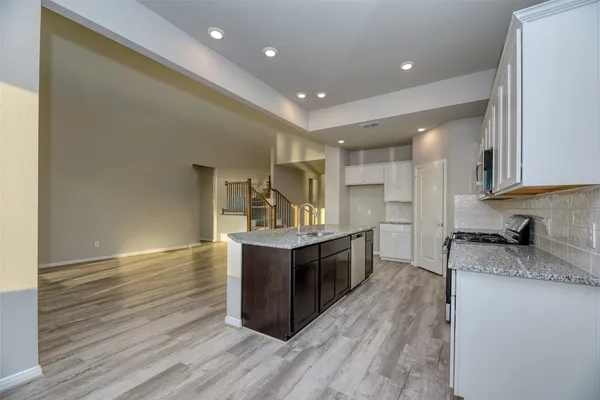 a kitchen with granite countertop a sink and cabinets