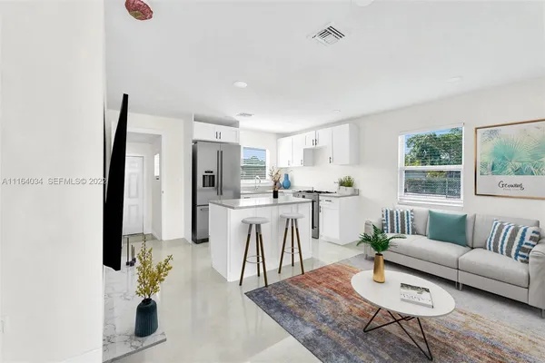 a living room with furniture kitchen view and a window