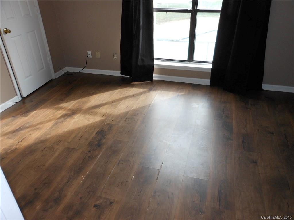 11054 Running Ridge Road, Unit 8415 Charlotte, NC 28226 - Photo 11 of 24 an empty room with wooden floor and windows
