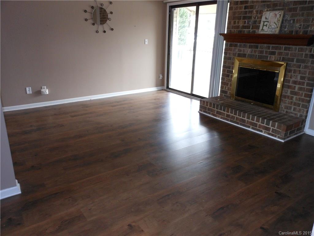 11054 Running Ridge Road, Unit 8415 Charlotte, NC 28226 - Photo 3 of 24 an empty room with wooden floor a fireplace and windows