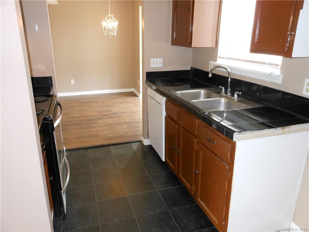 11054 Running Ridge Road, Unit 8415 Charlotte, NC 28226 - Photo 7 of 24 a kitchen with a sink a counter top space and cabinets