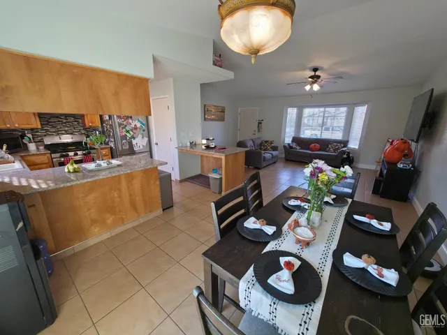 a living room with furniture a flat screen tv and a dining table