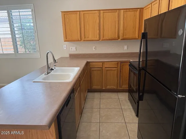 a kitchen with a sink a refrigerator and cabinets