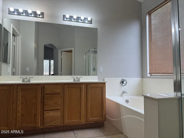 a bathroom with a tub sink and mirror