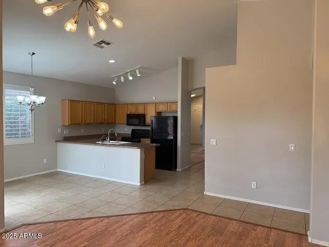 a large white kitchen with a refrigerator a microwave oven a sink and a counter space