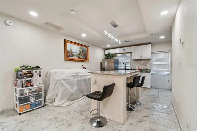 a kitchen with granite countertop a refrigerator and a stove top oven