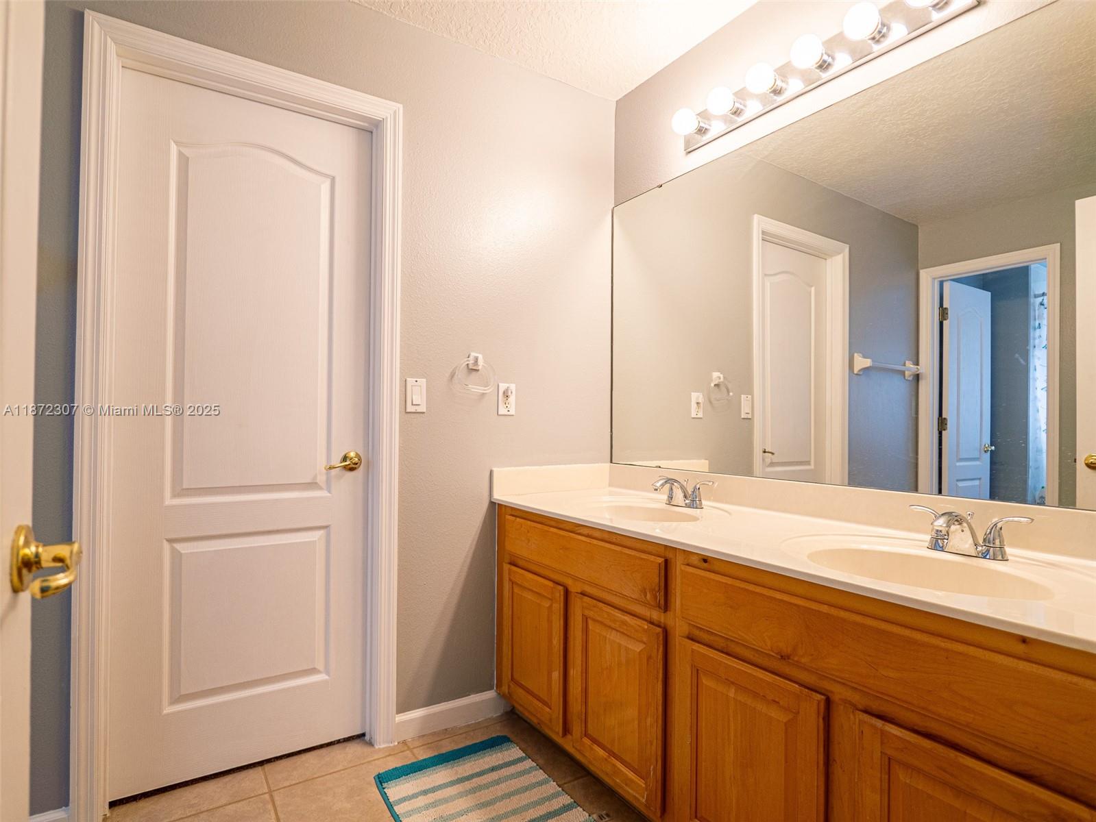 565 Hebrides Court Apopka, FL 32712 - Photo 16 of 32 a bathroom with a double vanity sink and a mirror