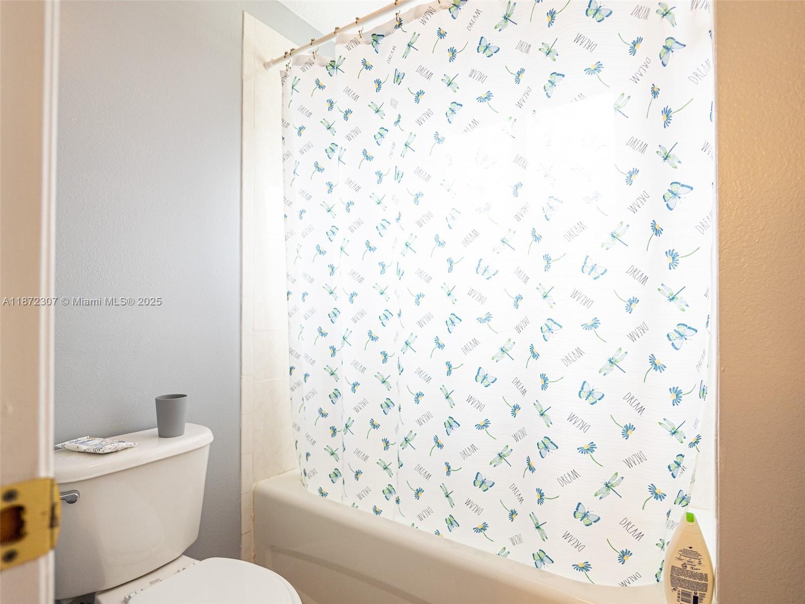 565 Hebrides Court Apopka, FL 32712 - Photo 18 of 32 a white toilet sitting next to a shower curtain