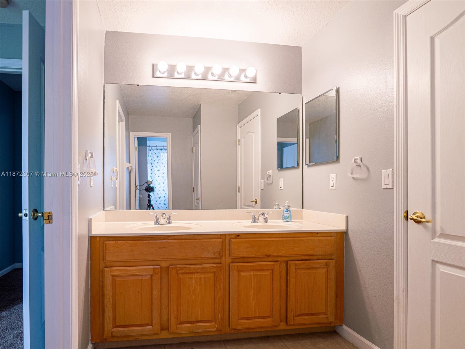 565 Hebrides Court Apopka, FL 32712 - Photo 19 of 32 a bathroom with a sink and a mirror