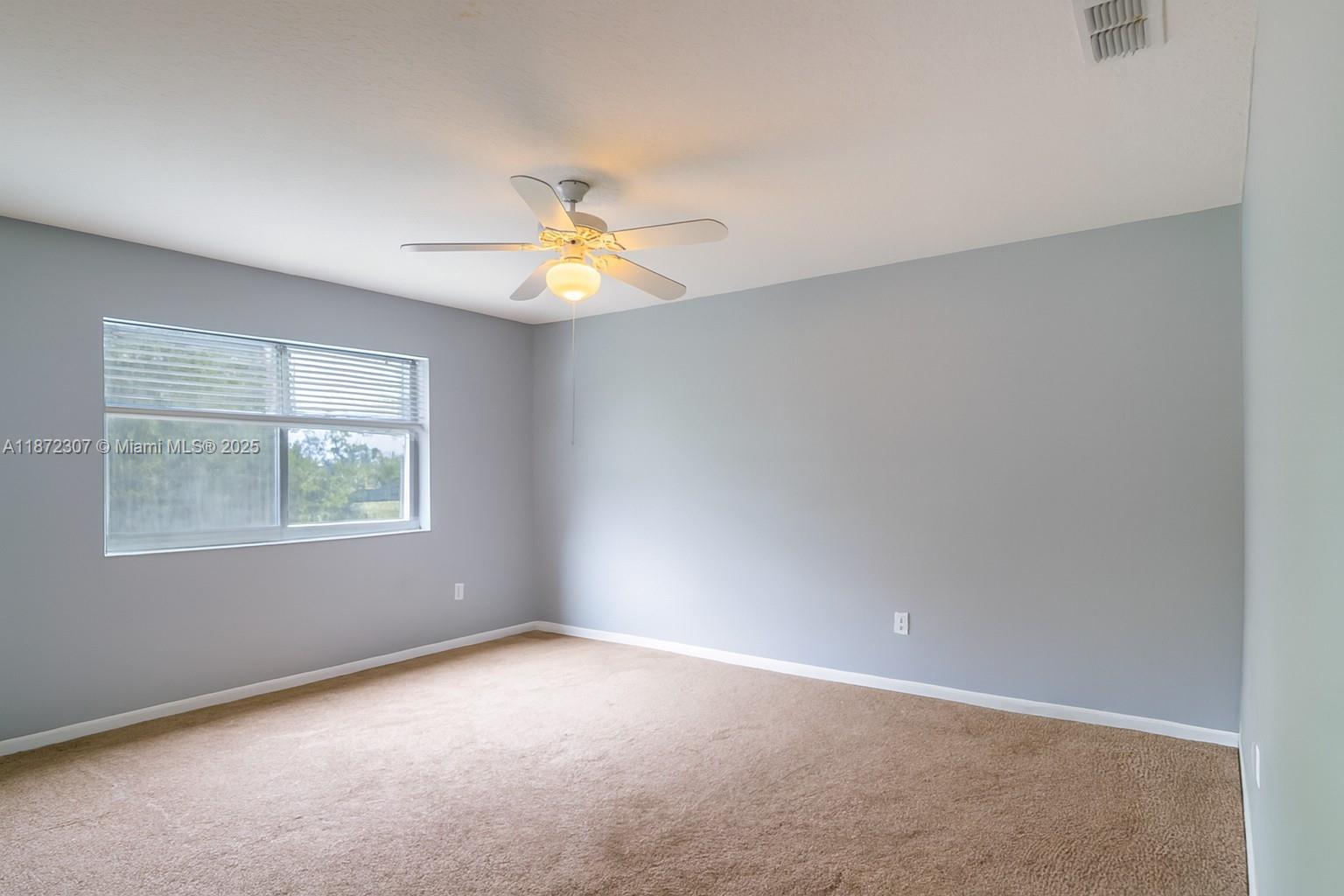 565 Hebrides Court Apopka, FL 32712 - Photo 23 of 32 an empty room with windows and chandelier fan