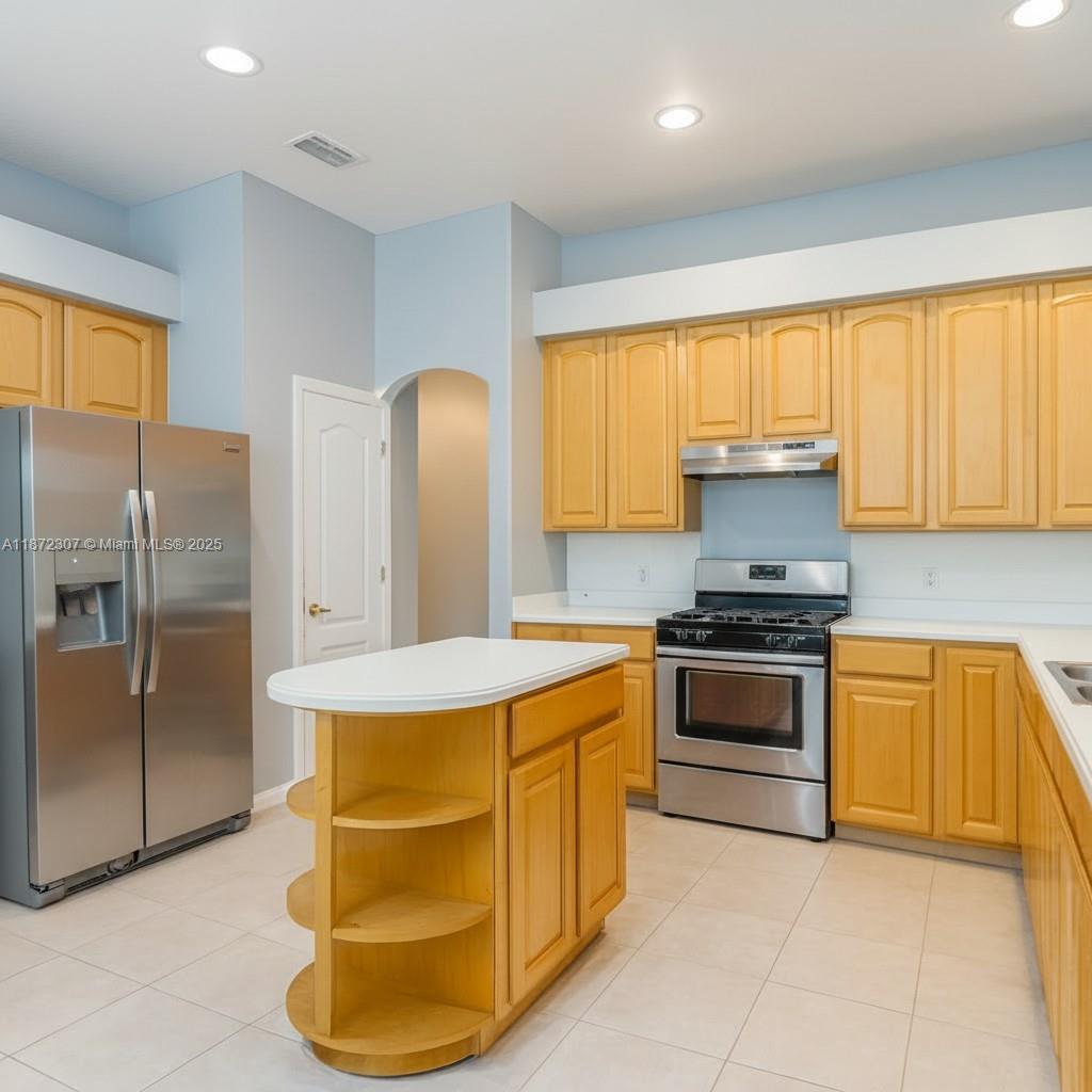 565 Hebrides Court Apopka, FL 32712 - Photo 6 of 32 a kitchen with stainless steel appliances granite countertop a sink stove and refrigerator