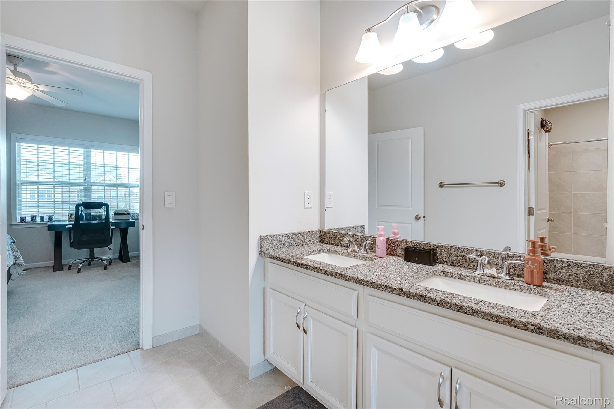 51011 Rockingham Drive Canton, MI 48188 - Photo 39 of 74 Bathroom with double vanity, curtained shower, ceiling fan, light tile patterned floors, and light colored carpet