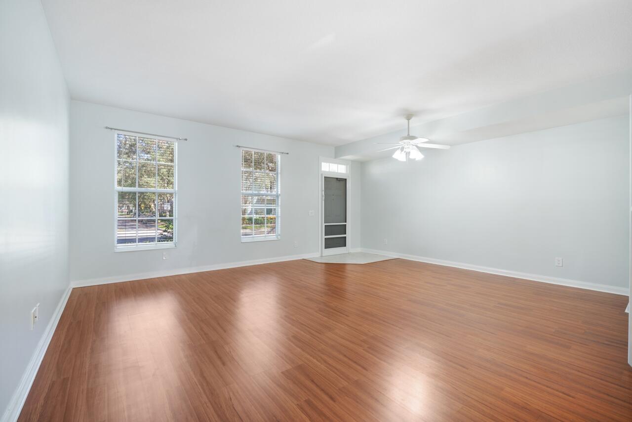 329 Legare Court Jupiter, FL 33458 - Photo 1 of 23 an empty room with wooden floor chandelier fan and windows