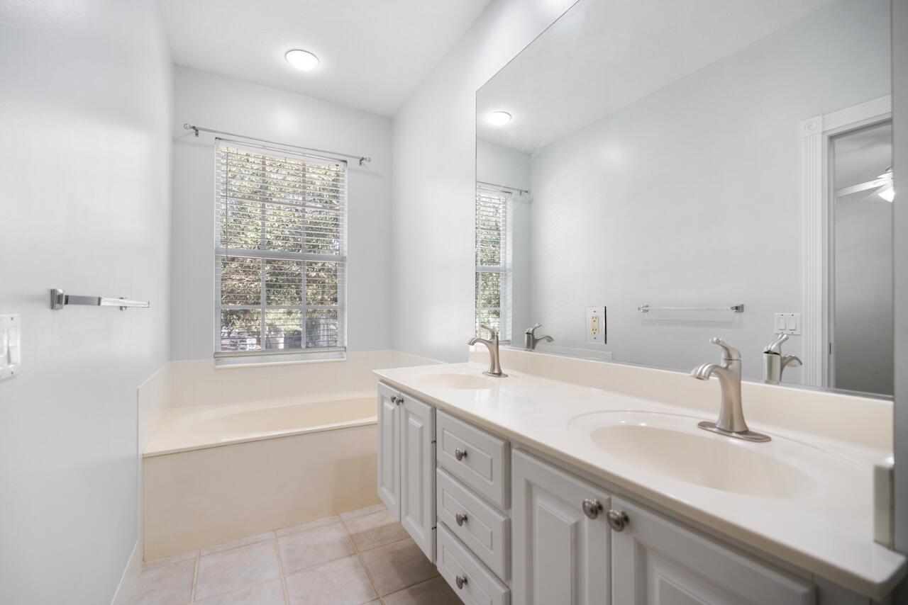 329 Legare Court Jupiter, FL 33458 - Photo 12 of 23 a bathroom with a sink double vanity granite tub shower and a mirror