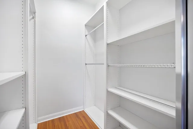 a view of walk in closet with empty racks