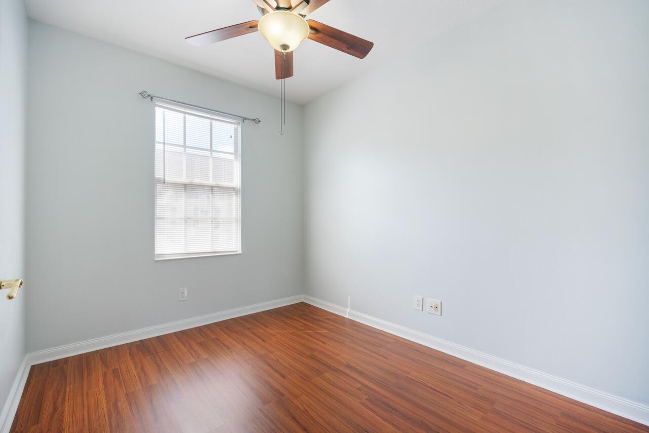 329 Legare Court Jupiter, FL 33458 - Photo 20 of 23 an empty room with wooden floor chandelier fan and windows