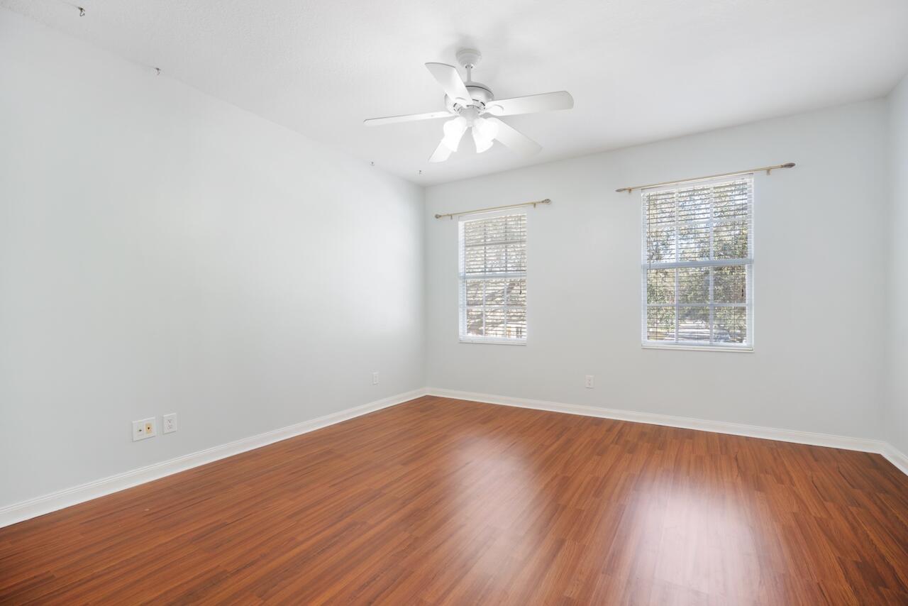 329 Legare Court Jupiter, FL 33458 - Photo 10 of 23 an empty room with wooden floor chandelier fan and windows