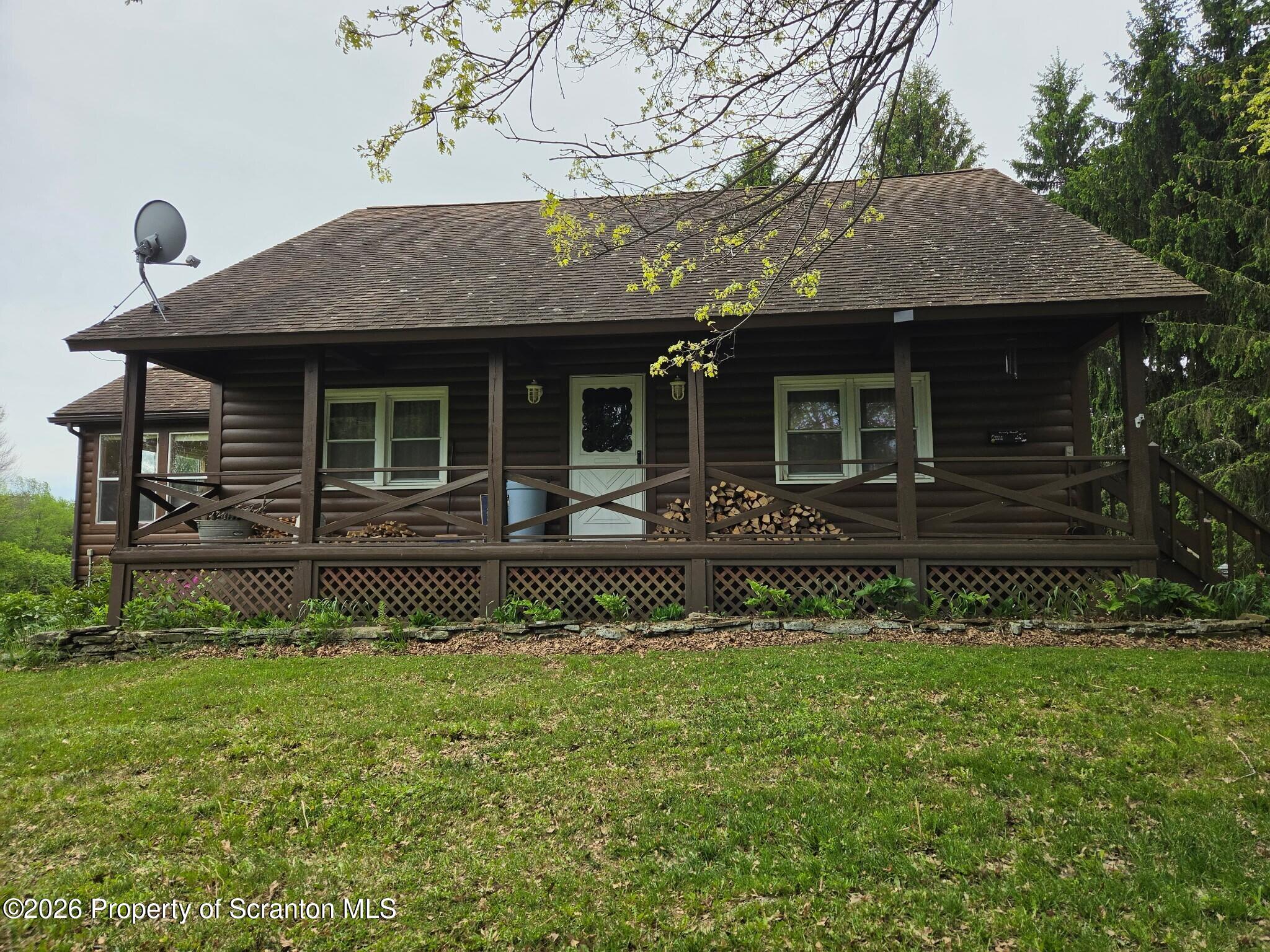 2590 Potter Hill Road Thompson, PA 18465 - Photo 1 of 43 a front view of a house with a garden