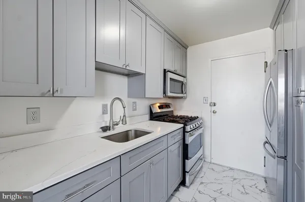 a kitchen with stainless steel appliances granite countertop a sink a stove and a refrigerator