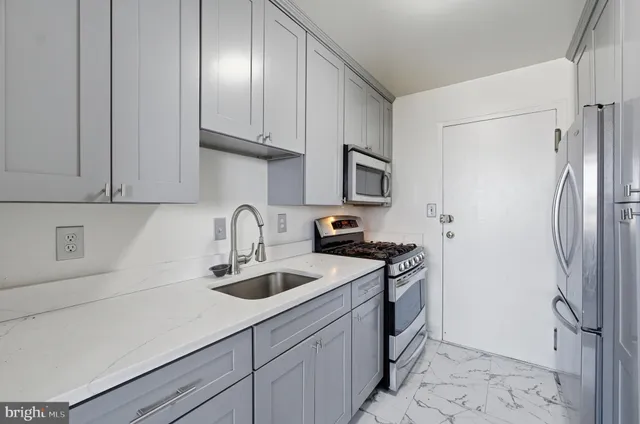 a kitchen with stainless steel appliances granite countertop a sink a stove and a refrigerator