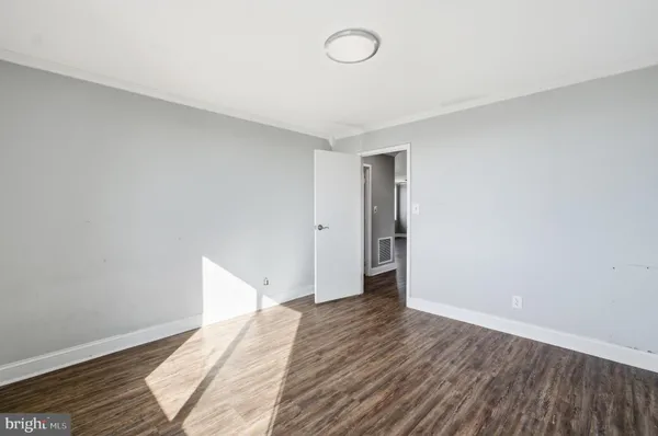 a view of empty room with wooden floor