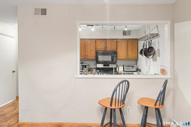 a kitchen with stainless steel appliances granite countertop a sink and a refrigerator
