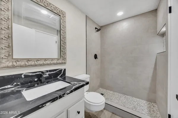 a bathroom with a granite countertop sink toilet and shower