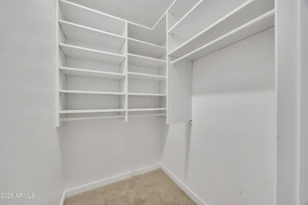 a view of walk in closet with empty racks