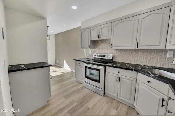a kitchen with white cabinets and white appliances