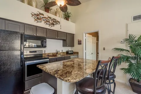 a kitchen with granite countertop a sink stainless steel appliances and cabinets