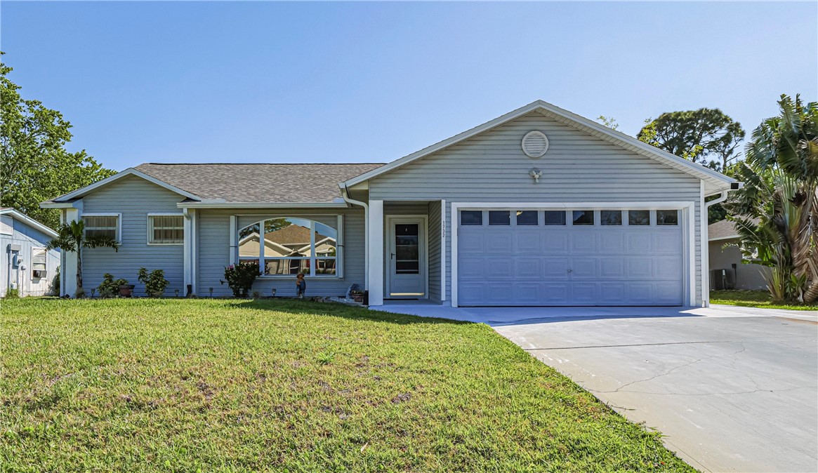 a view of a house with a yard and garage