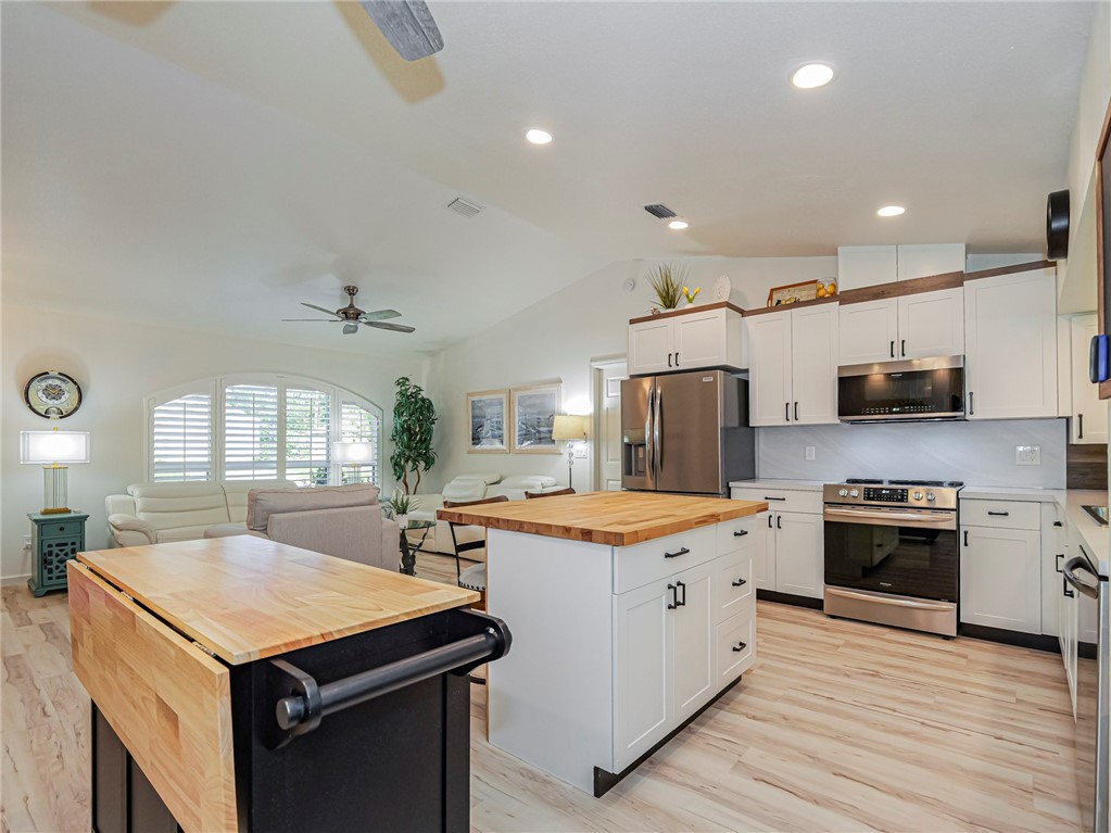 1732 Sunrise Lane Sebastian, FL 32958 - Photo 14 of 36 a kitchen with stainless steel appliances granite countertop a sink stove and refrigerator