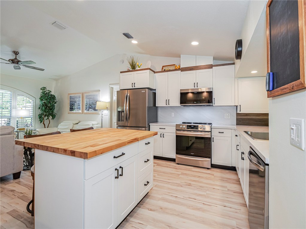1732 Sunrise Lane Sebastian, FL 32958 - Photo 10 of 36 a kitchen with stainless steel appliances granite countertop a stove top oven a sink and a refrigerator