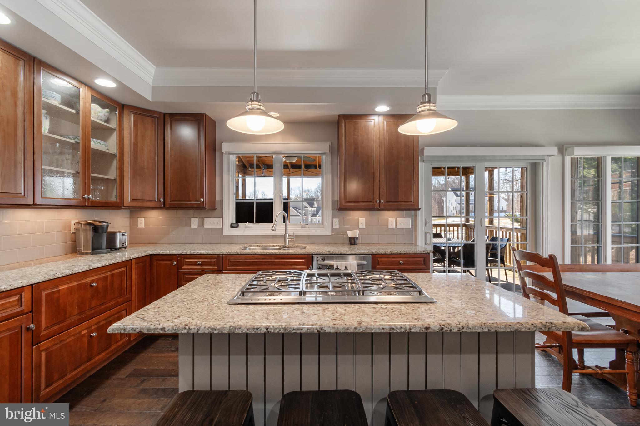 12911 Buckeye Drive North Potomac, MD 20878 - Photo 17 of 74 a kitchen with granite countertop a stove a sink dishwasher a dining table and chairs with wooden floor