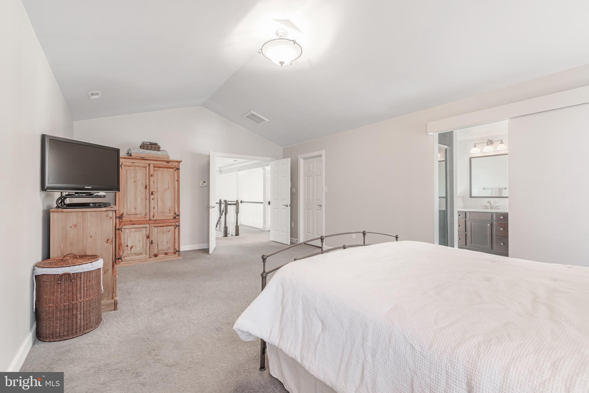 12911 Buckeye Drive North Potomac, MD 20878 - Photo 38 of 74 a spacious bedroom with a bed and a flat screen tv