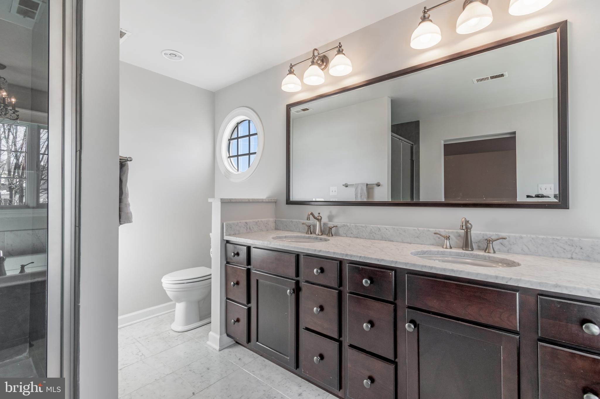 12911 Buckeye Drive North Potomac, MD 20878 - Photo 39 of 74 a bathroom with a toilet a double vanity sink and a mirror