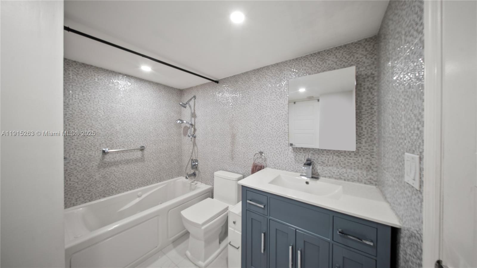 2030 South Ocean Drive, Unit 1716 Hallandale Beach, FL 33009 - Photo 12 of 15 a bathroom with a bathtub shower sink vanity mirror and toilet