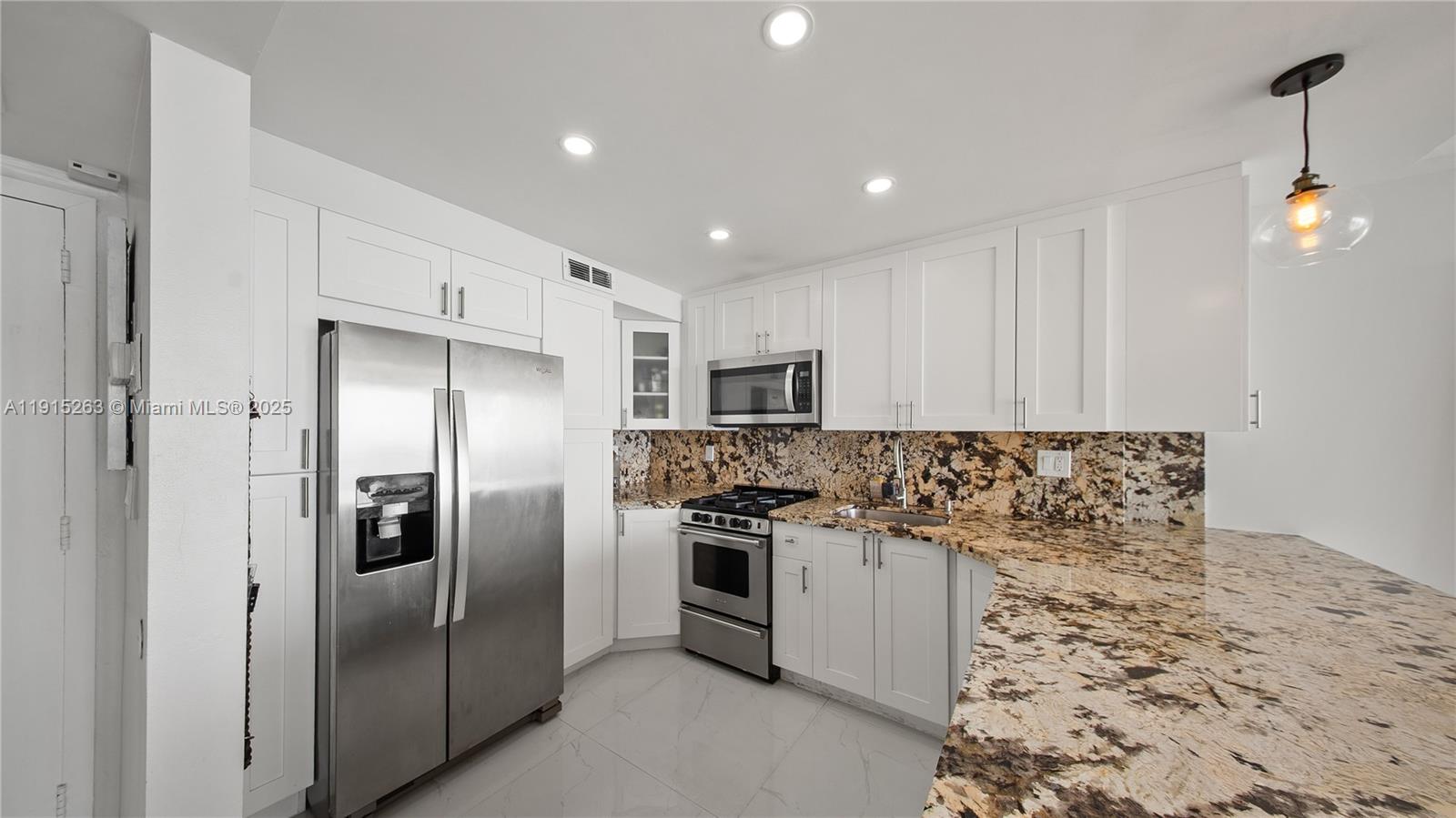 2030 South Ocean Drive, Unit 1716 Hallandale Beach, FL 33009 - Photo 9 of 15 a kitchen with stainless steel appliances granite countertop a refrigerator a stove and a sink