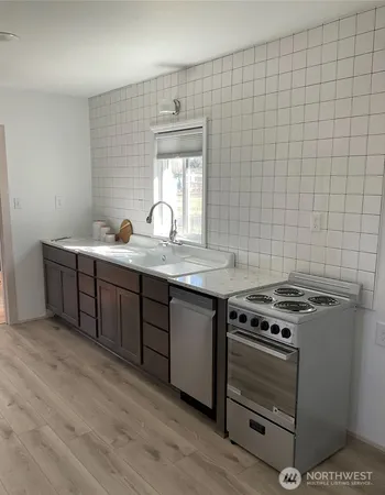 a room with a sink cabinets and a wooden floor